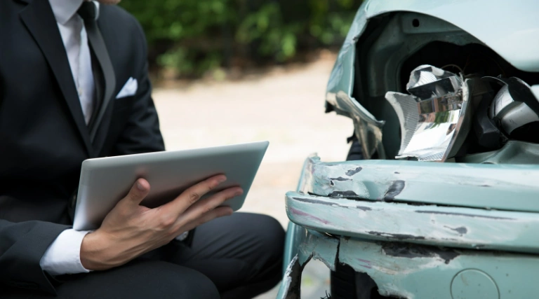 tablet w dłoniach, uszkodzone auto